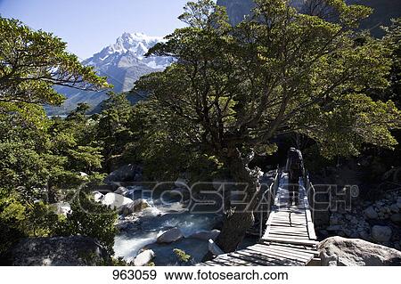 A person crossing a river while hiking through mountains, Patagonia, Chile View Large Photo Image Stock Photo - A person crossing a river while hiking through mountains, Patagonia, Chile. Fotosearch