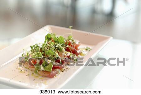 A plate of tuna sashimi with pea shoots on a table View Large Photo Image Stock Image - A plate of tuna sashimi with pea shoots on a table. Fotosearch