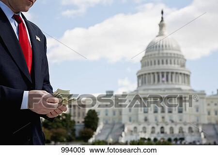A politician counting money in front of the US Capitol Building View Large Photo Image Stock Photography - A politician counting money in front of the US Capitol Building. Fotosearch
