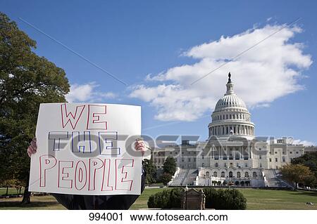 A protestor holding a placard in front of the US Capitol Building View Large Photo Image Stock Image - A protestor holding a placard in front of the US Capitol Building. Fotosearch