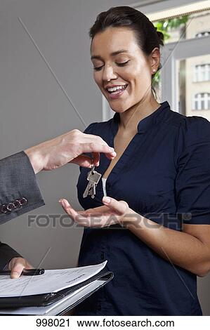 A real estate agent giving a woman the keys to her new home View Large Photo Image Stock Image - A real estate agent giving a woman the keys to her new home. Fotosearch