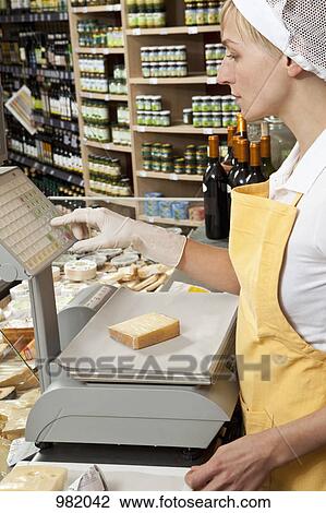 A sales clerk weighing a wedge of cheese View Large Photo Image Stock Image - A sales clerk weighing a wedge of cheese. Fotosearch