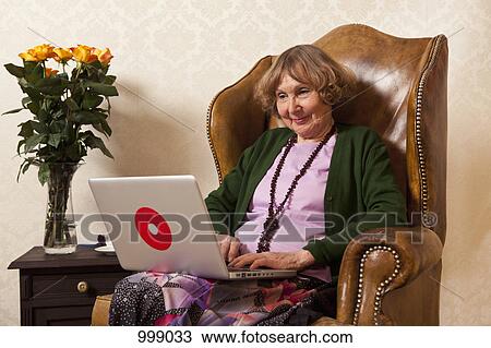 A senior woman relaxing with a laptop View Large Photo Image Stock Image - A senior woman relaxing with a laptop. Fotosearch