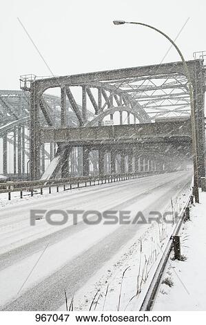 Stock Photo - A snowstorm across a road bridge. Fotosearch