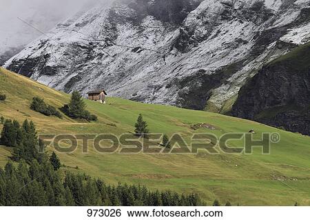 A snowy mountainside next to a green mountainside View Large Photo Image Stock Photograph - A snowy mountainside next to a green mountainside. Fotosearch