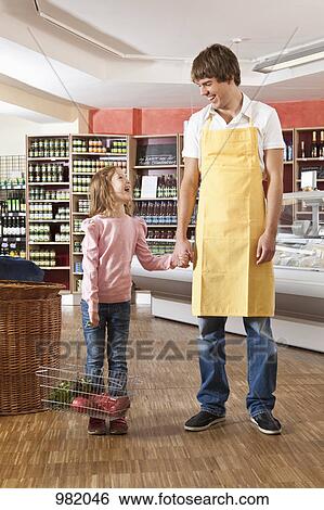 A supermarket clerk laughing with a young girl View Large Photo Image Stock Photograph - A supermarket clerk laughing with a young girl. Fotosearch