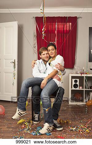 Stock Image - A tipsy woman sitting on her boyfriend's lap. Fotosearch