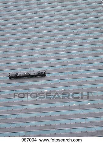 A window cleaning platform hanging on a building View Large Photo Image Picture - A window cleaning platform hanging on a building. Fotosearch
