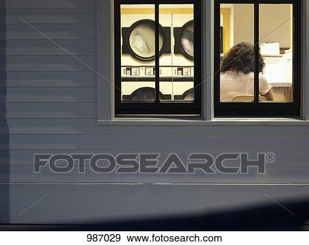 A woman in a laundry mat, rear view through window View Large Photo Image Stock Photo - A woman in a laundry mat, rear view through window. Fotosearch