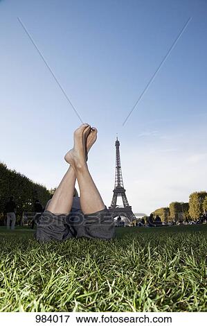 A woman laying in grass by Eiffel Tower, focus on feet View Large Photo Image Stock Photo - A woman laying in grass by Eiffel Tower, focus on feet. Fotosearch