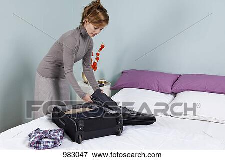 A woman packing a suitcase View Large Photo Image Stock Photo - A woman packing a suitcase. Fotosearch