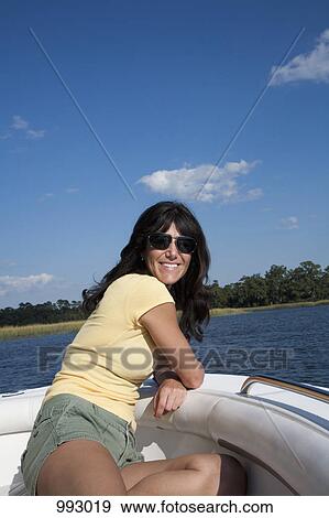 Stock Photo - A woman relaxing on a motorboat. Fotosearch