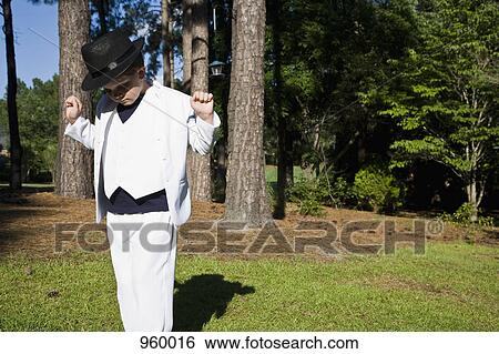 A young boy in a white suit dancing like Michael Jackson, outdoors View Large Photo Image Stock Photograph - A young boy in a white suit dancing like Michael Jackson, outdoors. Fotosearch