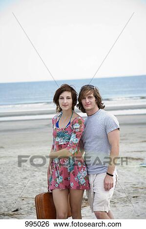 Stock Photograph - A young couple at the beach, portrait. Fotosearch