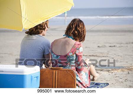 A young couple at the beach, rear view View Large Photo Image Stock Image - A young couple at the beach, rear view. Fotosearch