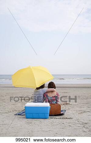 A young couple at the beach, rear view View Large Photo Image Stock Image - A young couple at the beach, rear view. Fotosearch