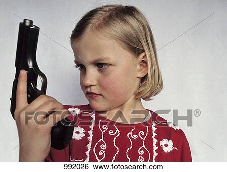 A young girl holding a gun View Large Photo Image Stock Photograph - A young girl holding a gun. Fotosearch
