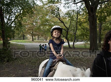 Stock Image - A young girl horseback riding. Fotosearch