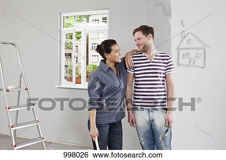 A young man and woman renovating an apartment View Large Photo Image Stock Photograph - A young man and woman renovating an apartment. Fotosearch