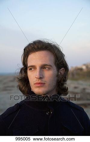 Stock Photography - A young man at the beach, portrait. Fotosearch