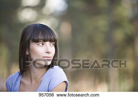 A young woman looking over her shoulder, portrait View Large Photo Image Stock Photograph - A young woman looking over her shoulder, portrait. Fotosearch