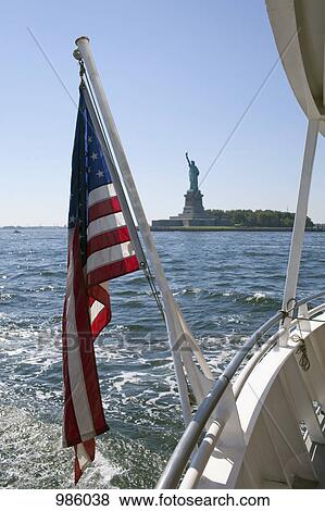 American flag on a ferry, Statue of Liberty in background View Large Photo Image Stock Photo - American flag on a ferry, Statue of Liberty in background. Fotosearch