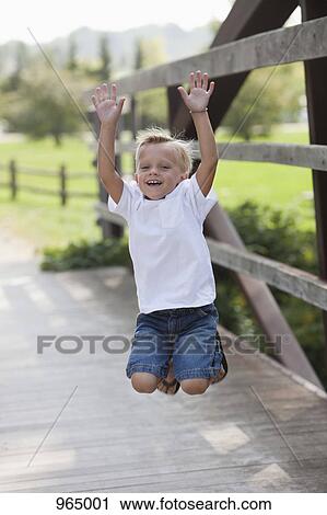 Boy jumping on bridge View Large Photo Image Stock Image - Boy jumping on bridge. Fotosearch