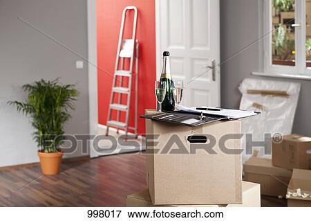 Champagne and a contract in a living room with moving boxes View Large Photo Image Stock Photo - Champagne and a contract in a living room with moving boxes. Fotosearch