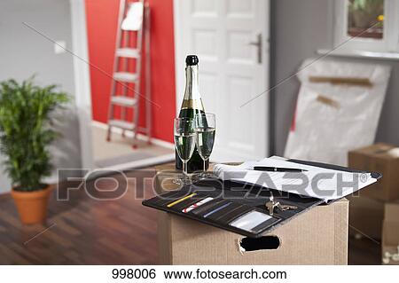 Champagne and a contract in a living room with moving boxes View Large Photo Image Stock Photograph - Champagne and a contract in a living room with moving boxes. Fotosearch