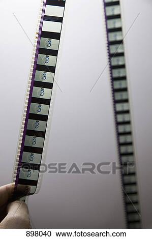 Detail of a man holding a strip of film View Large Photo Image Stock Image - Detail of a man holding a strip of film. Fotosearch