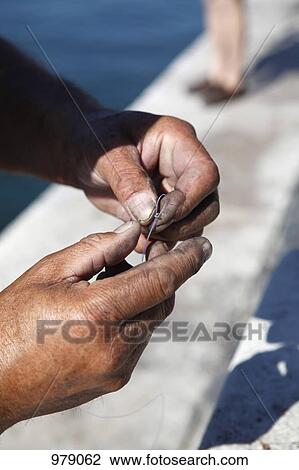 Detail of a man tying a fishing line to a hook View Large Photo Image Stock Image - Detail of a man tying a fishing line to a hook. Fotosearch