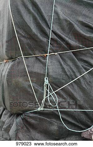 Stock Image - Detail of a tarpaulin and ropes. Fotosearch
