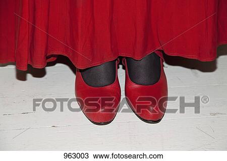 Stock Image - Detail of a woman wearing a red skirt and red shoes. Fotosearch