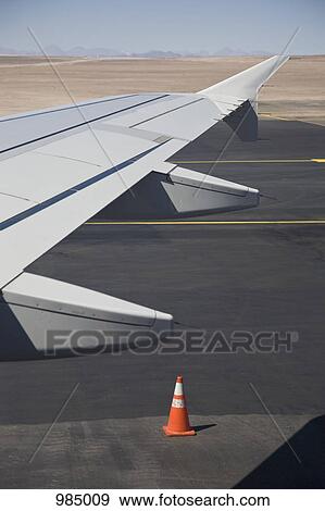 Stock Photo - Detail of the wing of an airplane on a tarmac. Fotosearch