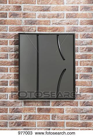 Stock Image - Framed picture of broken bars hanging on a fake brick wall. Fotosearch