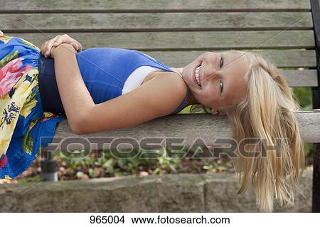 Girl lying on bench View Large Photo Image Picture - Girl lying on bench. Fotosearch