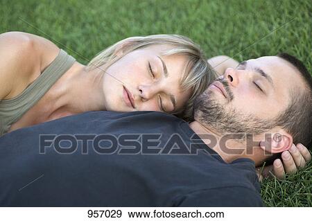 Man and woman sleeping on grass View Large Photo Image Stock Photo - Man and woman sleeping on grass . Fotosearch