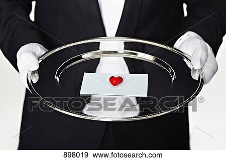 Midsection of a man in a tuxedo holding a letter on a silver platter View Large Photo Image Stock Photo - Midsection of a man in a tuxedo holding a letter on a silver platter. Fotosearch