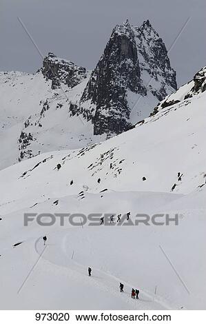 People hiking up a snowy mountain footpath View Large Photo Image Stock Image - People hiking up a snowy mountain footpath. Fotosearch