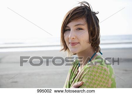 Stock Image - Portrait of a young woman at the beach. Fotosearch