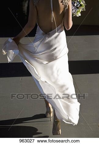Rear view of a bride walking View Large Photo Image Stock Photo - Rear view of a bride walking. Fotosearch