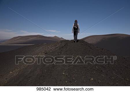 Rear view of a woman hiking over Lonquimay Volcano, Chile View Large Photo Image Stock Image - Rear view of a woman hiking over Lonquimay Volcano, Chile. Fotosearch