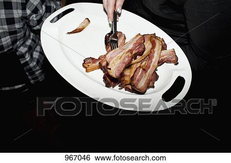 Slices of bacon on a plate View Large Photo Image Stock Photograph - Slices of bacon on a plate. Fotosearch