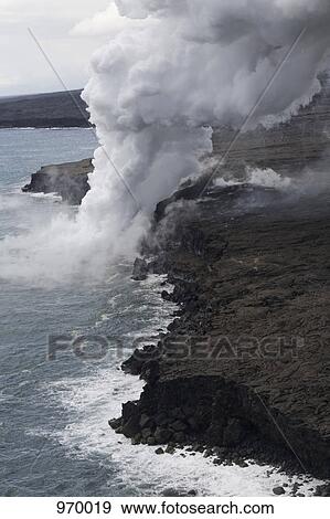 Stock Photo - Steam from volcano flowing into Hawaiian sea. Fotosearch