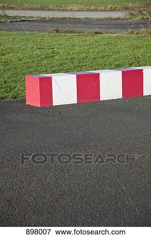 Striped concrete barrier in a parking lot View Large Photo Image Stock Photo - Striped concrete barrier in a parking lot. Fotosearch