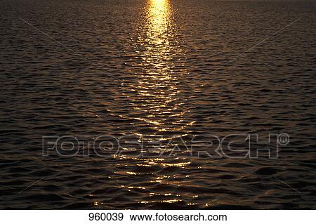 The sun setting on a rippled sea View Large Photo Image Stock Photo - The sun setting on a rippled sea. Fotosearch