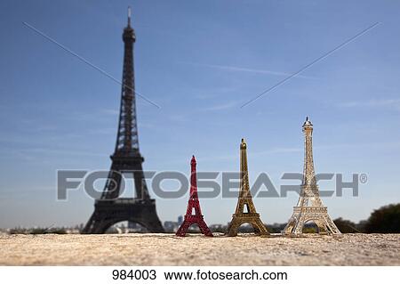 Three Eiffel Tower replica souvenirs next to the real Eiffel Tower, focus on foreground View Large Photo Image Stock Image - Three Eiffel Tower replica souvenirs next to the real Eiffel Tower, focus on foreground . Fotosearch