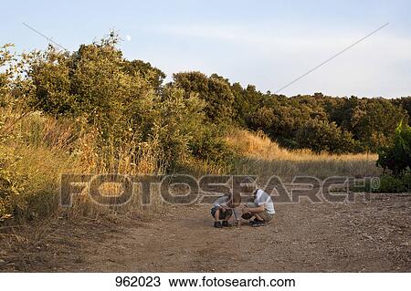 Stock Image - Two boys playing on a dirt path. Fotosearch