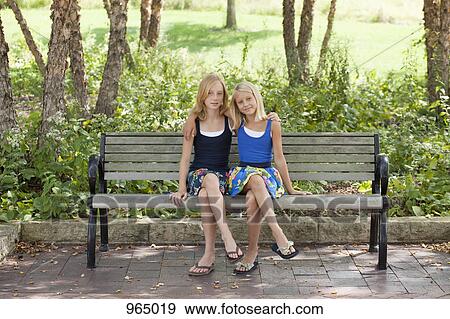 Two Girls legs crossed on a bench View Large Photo Image Stock Photo - Two Girls legs crossed on a bench . Fotosearch