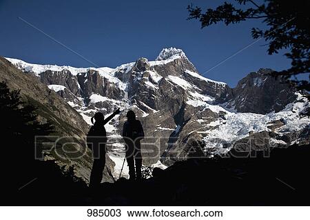Two people in silhouette standing below snowy mountains, Torres del Paine National Park, Chile View Large Photo Image Stock Image - Two people in silhouette standing below snowy mountains, Torres del Paine National Park, Chile. Fotosearch